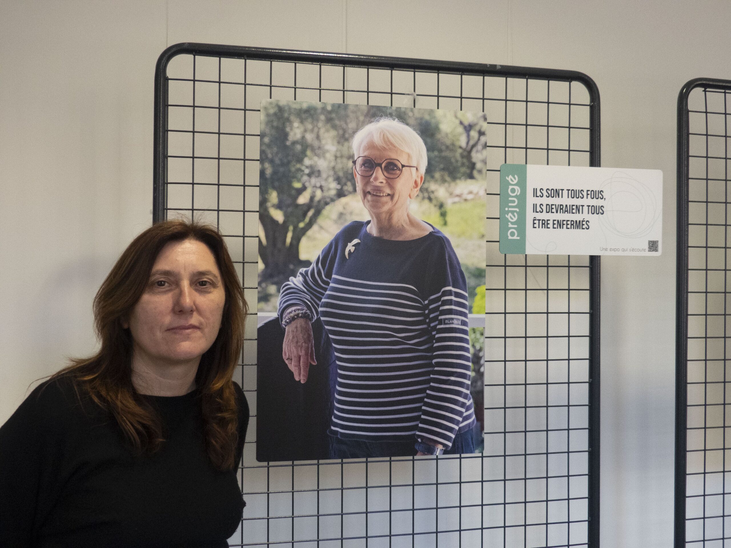 La responsable de la médiathéque Jules Verne devant une photographie de l'exposition L'Echo de nos folies présentée jusqu'au 27 avril 2026