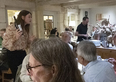 Le repas commence et une vigneronne présente son vin aux participants